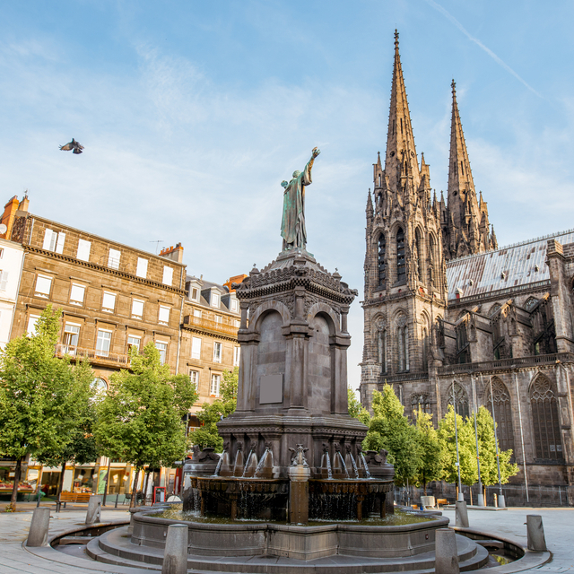 Vue de la cathédrale de Clermont-Ferrand avec le Puy de Dôme en arrière-plan et ses commerces locaux optimisés pour le référencement local avec BravoClient.